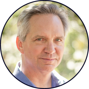 Portrait of a middle-aged man with gray hair outdoors.